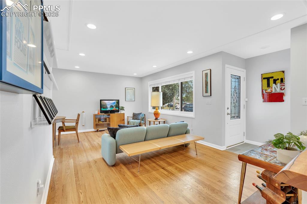 Image 9 of 50: Living room with recessed lighting and light wood-style floors