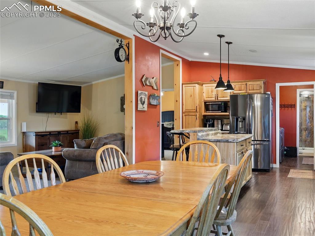 Image 11 of 45: Dining area featuring ornamental molding, dark wood-type flooring, and a ch