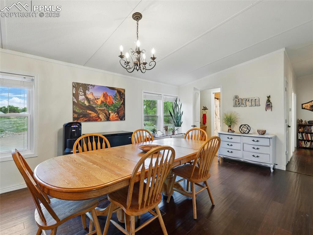 Image 12 of 45: Dining room with chandelier and dark flooring