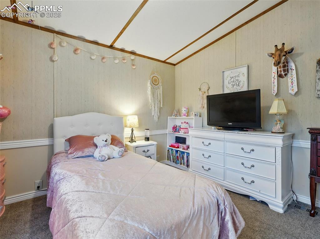 Image 21 of 45: Third Bedroom with carpet and vaulted ceiling
