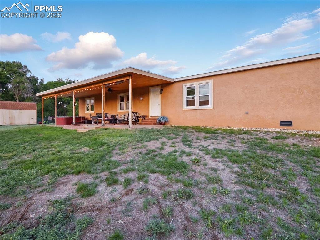 Image 33 of 45: Back of house with stucco siding, a patio area, and a yard