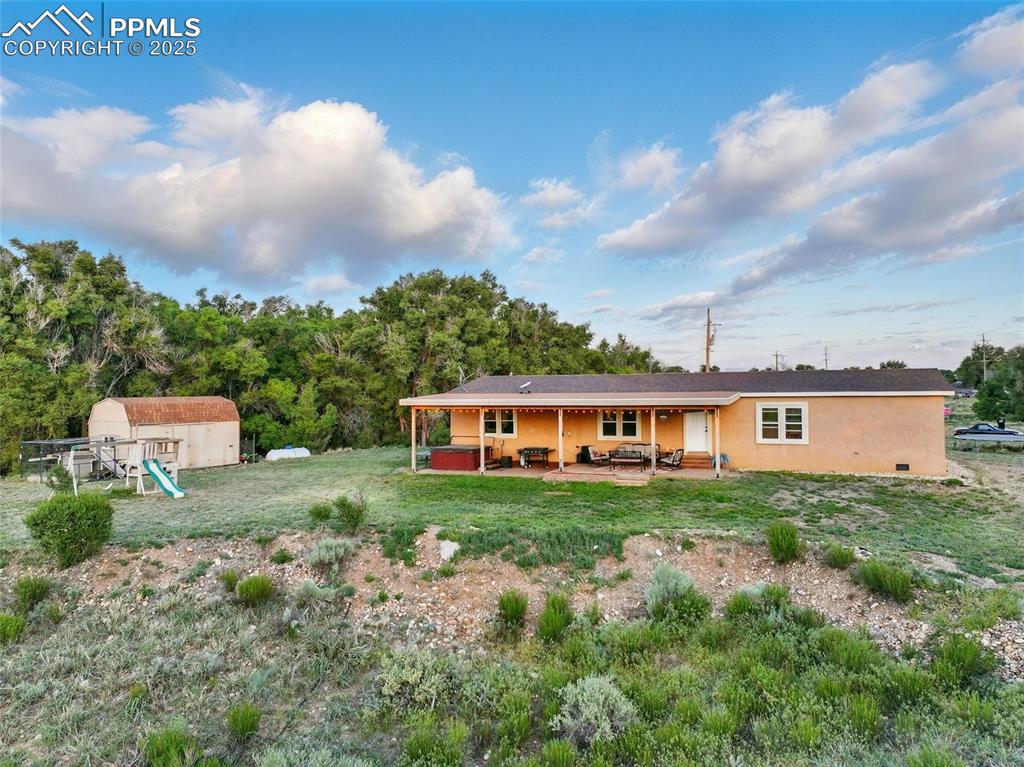 Image 40 of 45: View of back of home with a patio area, stucco siding, and a front yard