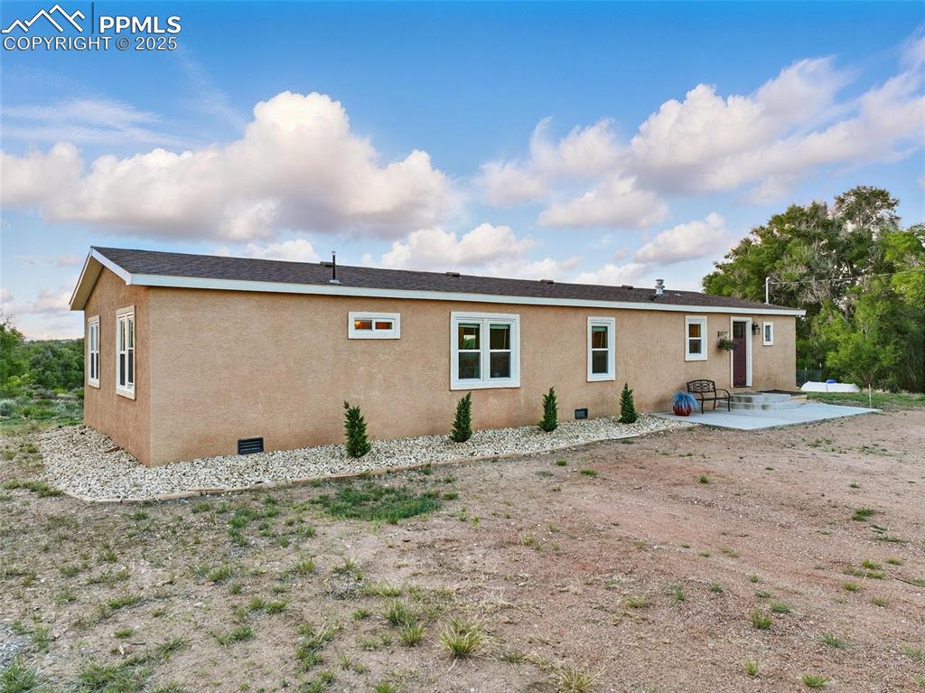 Image 41 of 45: Front of house featuring a patio area, stucco siding, and crawl space