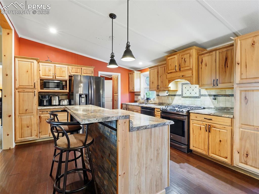 Image 8 of 45: Kitchen with stainless steel appliances, vaulted ceiling, hickory cabinets,