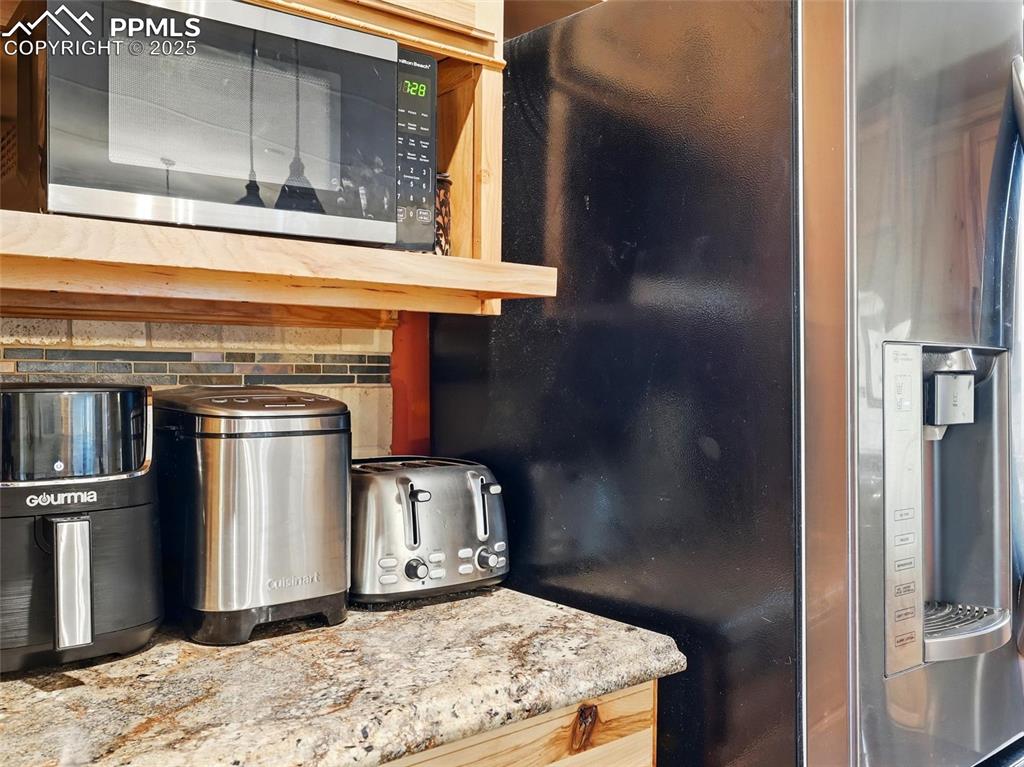 Image 9 of 45: Kitchen view of appliances with stainless steel finishes and backsplash