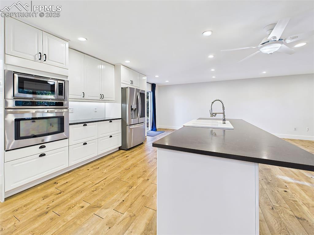 Image 11 of 50: Generously sized island faces a wall of premium stainless steel appliances,