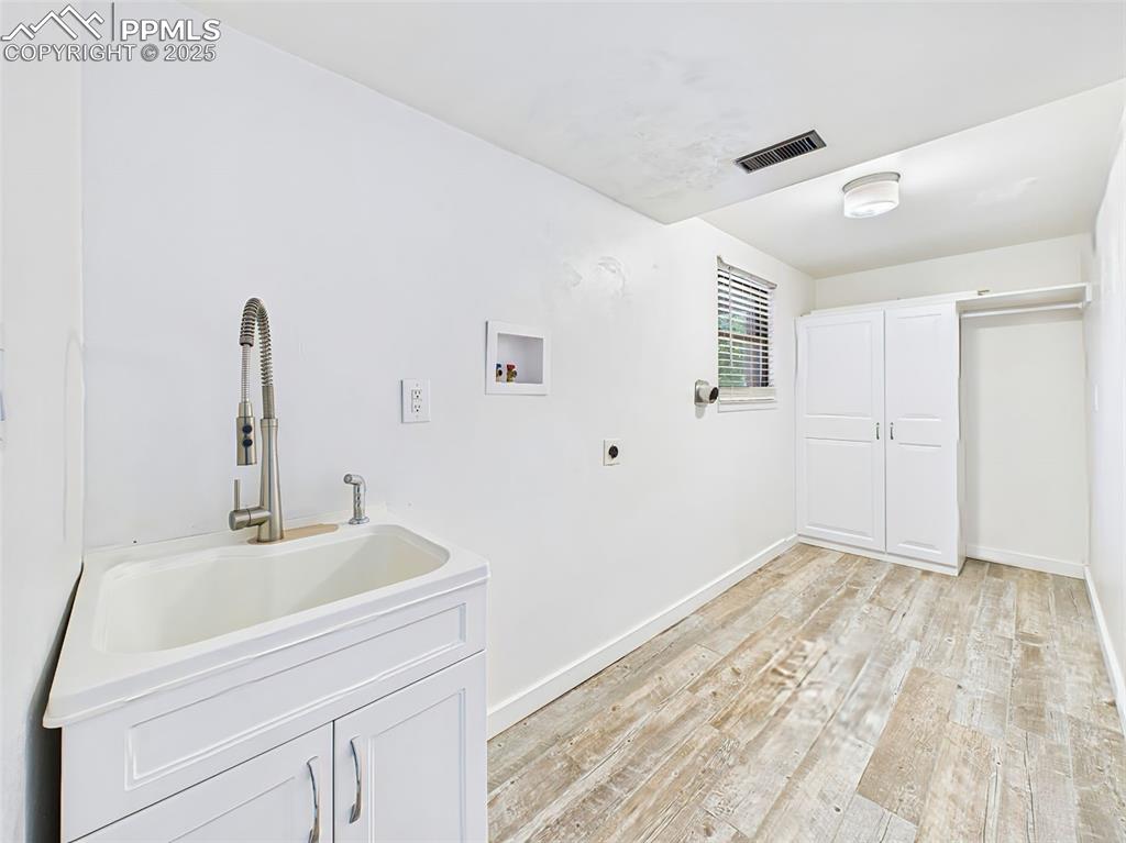 Image 27 of 50: Laundry with sink storage closet and window