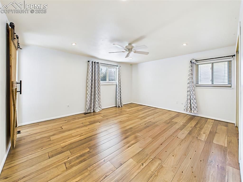 Image 28 of 50: Comfortable bedroom with neutral carpet, ceiling fan, and closet storage—re