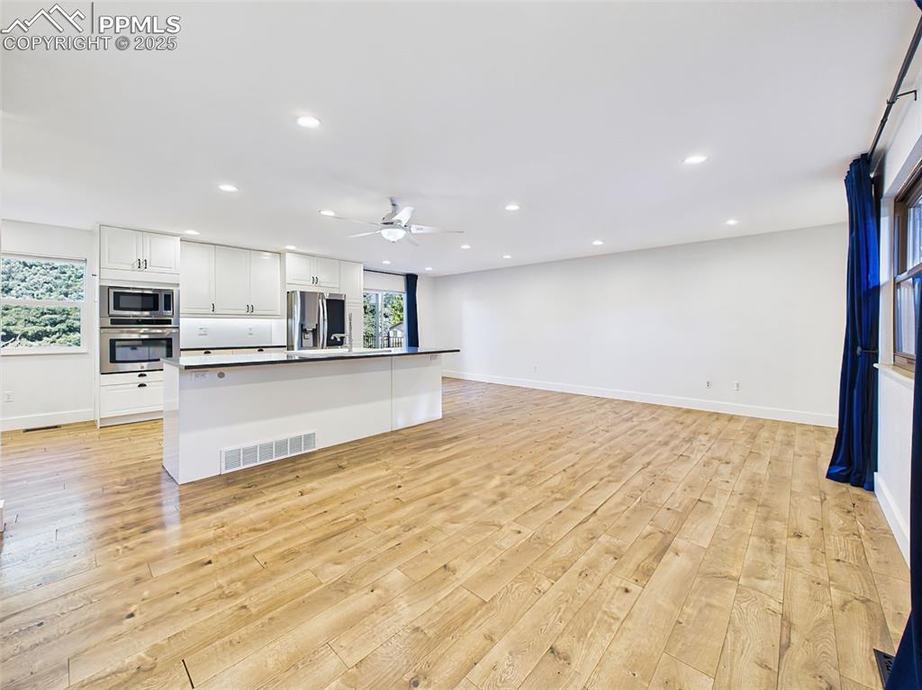 Image 3 of 50: Expansive open-concept layout features a sleek modern kitchen with stainles