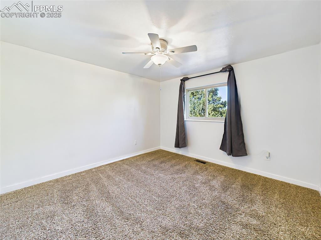 Image 31 of 50: Spacious secondary bedroom with plush carpet, ample closet space, and brigh