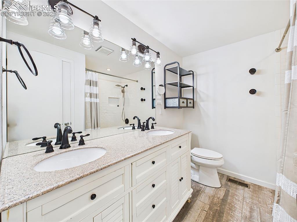 Image 35 of 50: Bright and functional bathroom featuring a dual-sink vanity with granite co