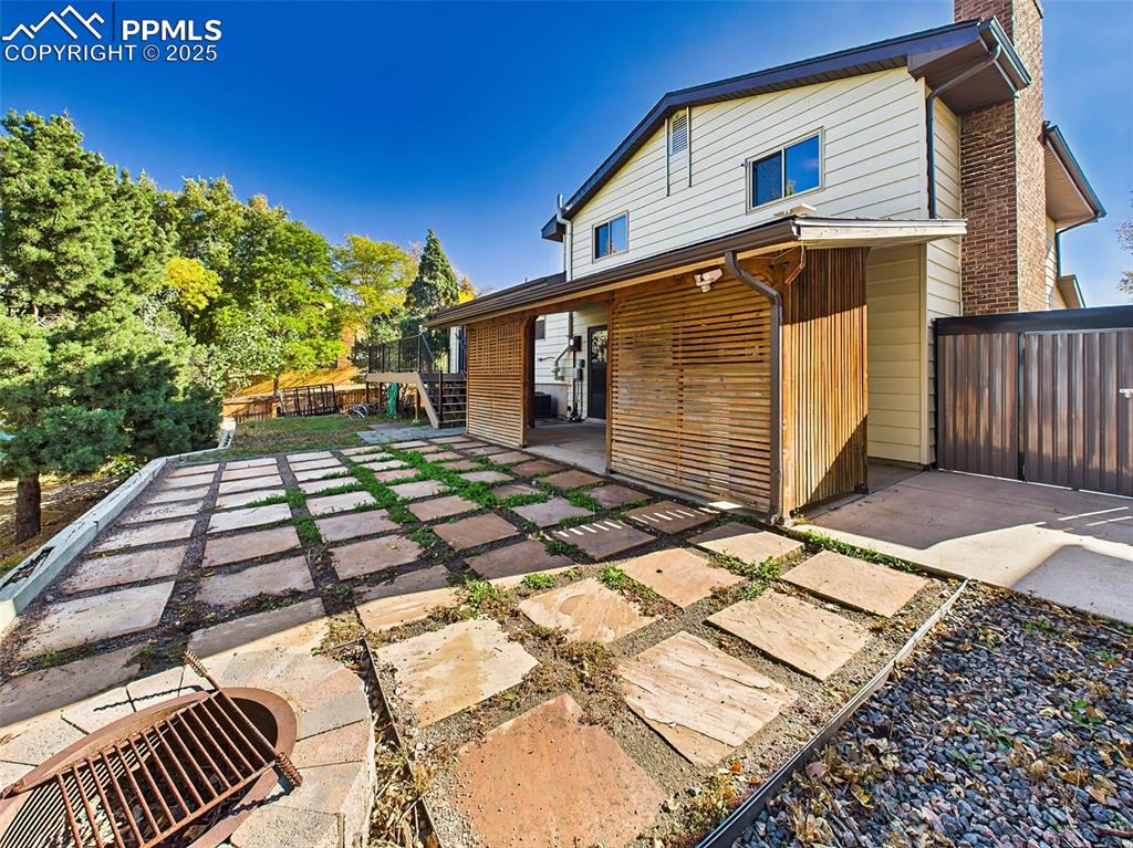 Image 37 of 50: The fully fenced backyard includes a flagstone patio, raised garden beds, a