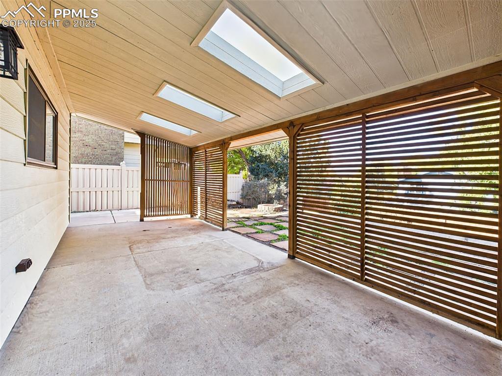 Image 39 of 50: Unique covered patio with privacy slats and skylights—an ideal spot for sha
