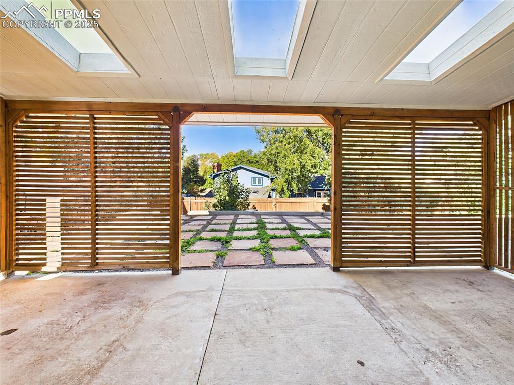 Image 41 of 50: The patio opens directly to the backyard and stone-paved area, seamlessly c