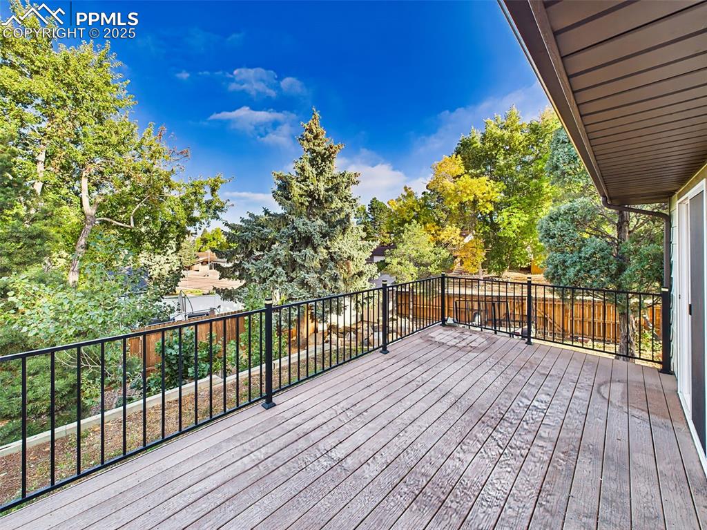 Image 45 of 50: Durable composite deck with metal railings and sliding glass door access to