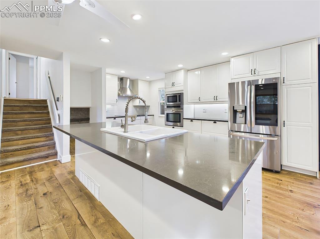 Image 7 of 50: Expansive kitchen island with deep farmhouse sink, sleek black countertops,