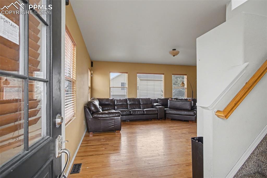Image 11 of 33: Living room featuring light wood finished floors and stairs