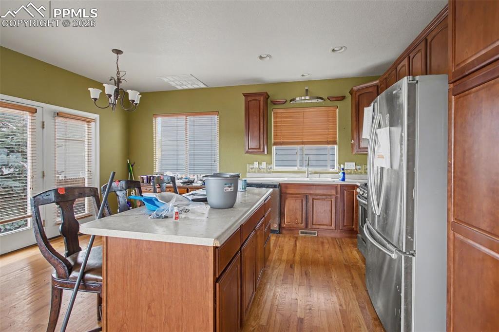 Image 16 of 33: Kitchen with stainless steel appliances, light countertops, light wood-styl