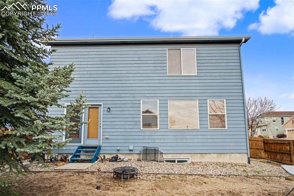 Image 32 of 33: Back of house with entry steps and an outdoor fire pit