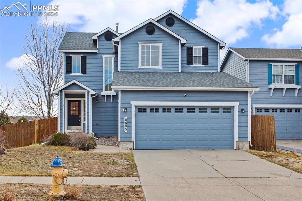 Image 8 of 33: Traditional home featuring concrete driveway, a garage, and roof with shing
