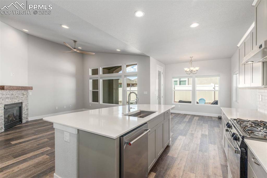 Image 11 of 46: Kitchen with open floor plan, stainless steel appliances, gray cabinets, da