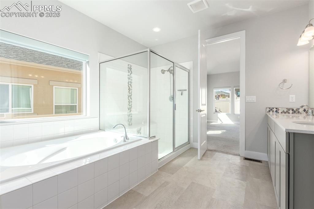 Image 19 of 46: Bathroom with double vanity, a shower, and a bath