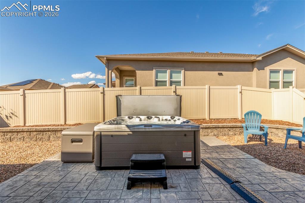 Image 33 of 46: Fenced backyard with a patio area 