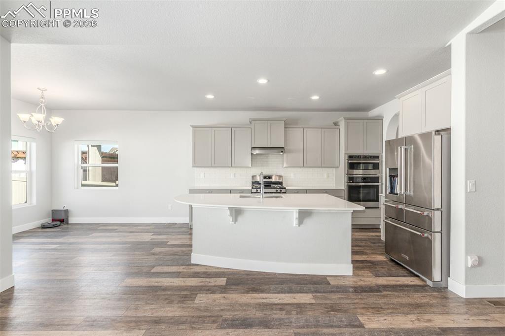 Image 9 of 46: Kitchen featuring appliances with stainless steel finishes, decorative back