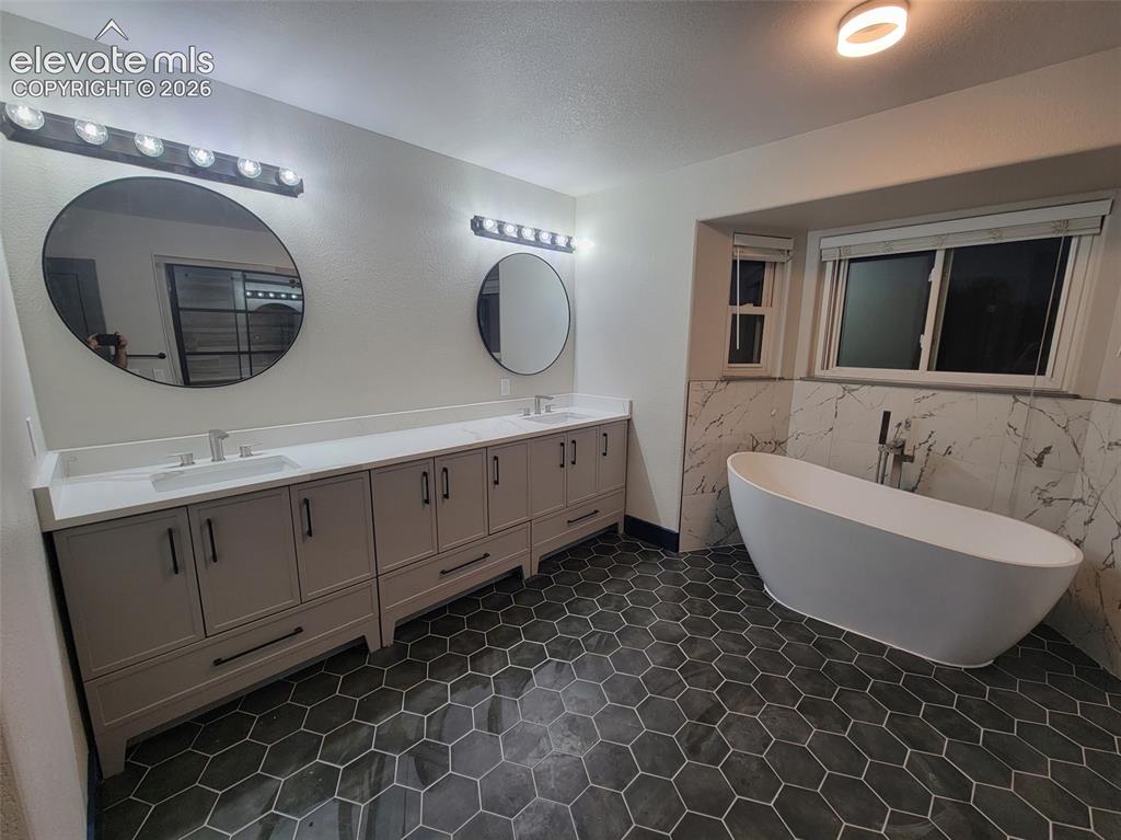 Image 47 of 47: Freestanding soaking tub, dual vanity with undermount sinks, hexagon tile f