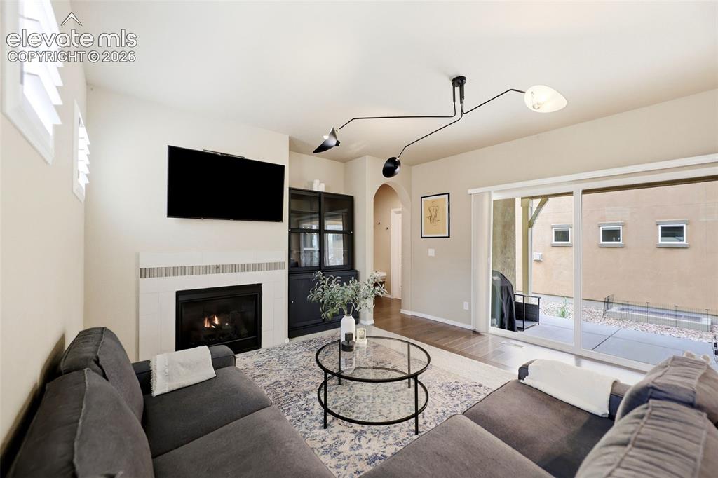 Image 15 of 48: Fireplace with tiled surround, ceiling-mounted multi-directional light fixt