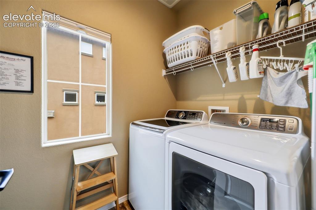 Image 19 of 48: Dedicated laundry area featuring a window, built-in wire shelving, and neut