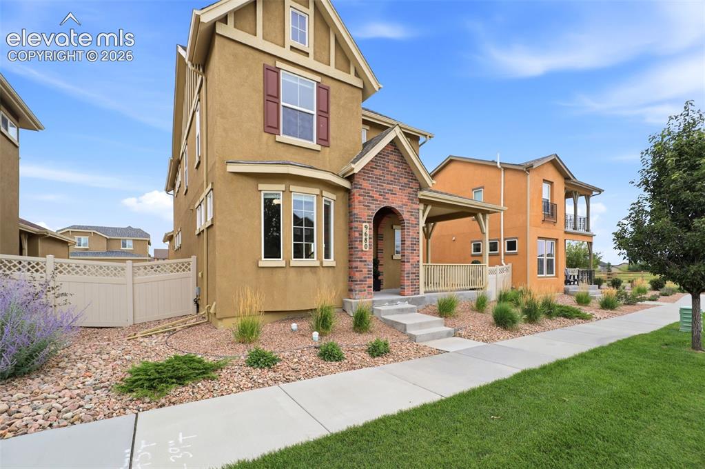 Image 2 of 48: Stucco exterior featuring a brick-accented entry, covered front porch with 