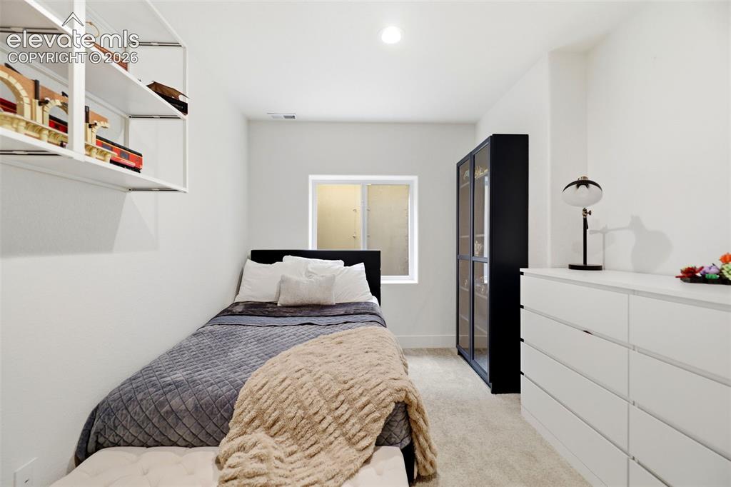 Image 21 of 48: Recessed ceiling lighting, wall-mounted open shelving, a window with a fros