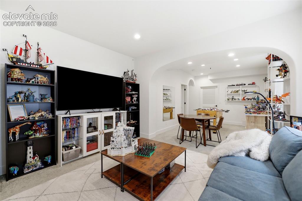 Image 22 of 48: Recessed lighting illuminates an open-concept entertainment space featuring