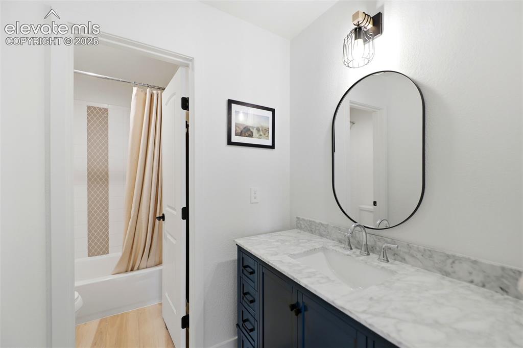 Image 25 of 48: Dark wood-finish vanity with a white basin and polished chrome faucet