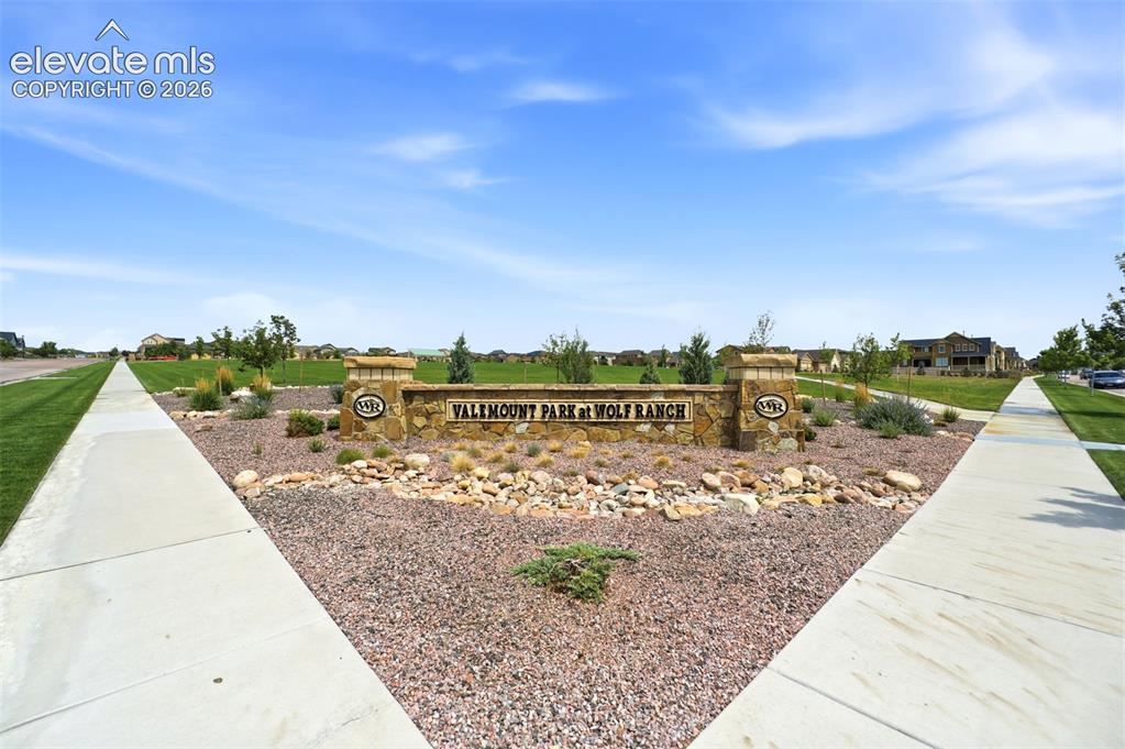 Image 38 of 48: Stone-clad community entrance sign with integrated landscaping