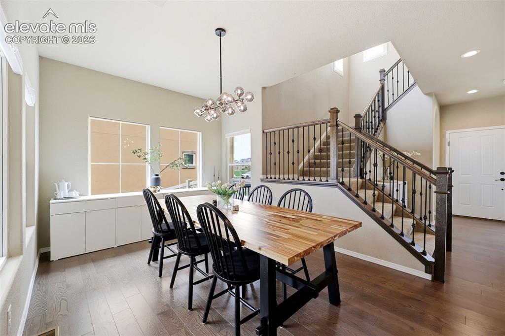 Image 9 of 48: Wood flooring, staircase with dark wood banister and wrought iron balusters
