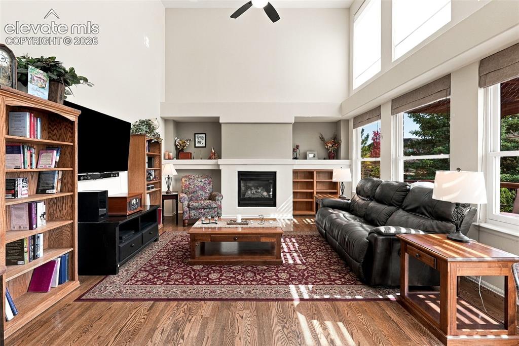 Image 15 of 50: Wood-finish flooring, high vaulted ceilings, and a built-in fireplace with