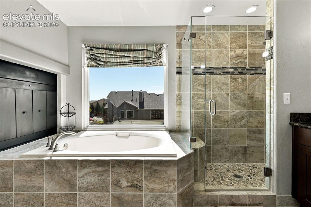Image 23 of 50: Soaking tub with tile surround, glass-enclosed shower, mosaic tile shower f