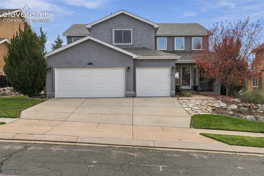 Image 3 of 50: Two-story stucco exterior with a two-car garage