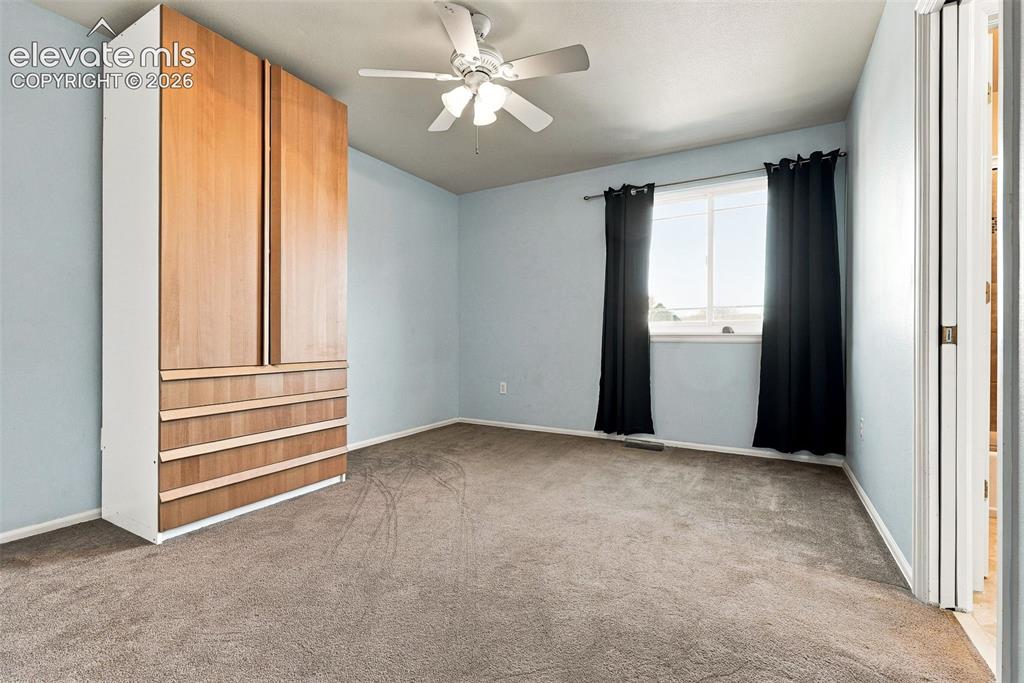 Image 31 of 50: Wall-mounted storage unit with wood-finish doors and drawers, neutral carpe