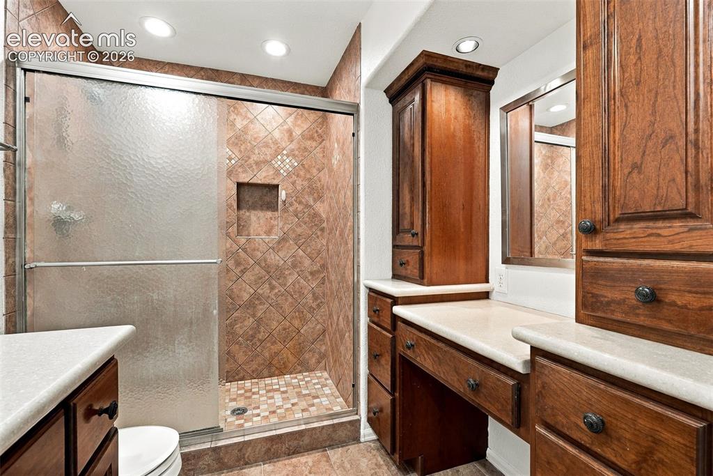 Image 39 of 50: Tiled shower enclosure with a recessed shelf and glass sliding door