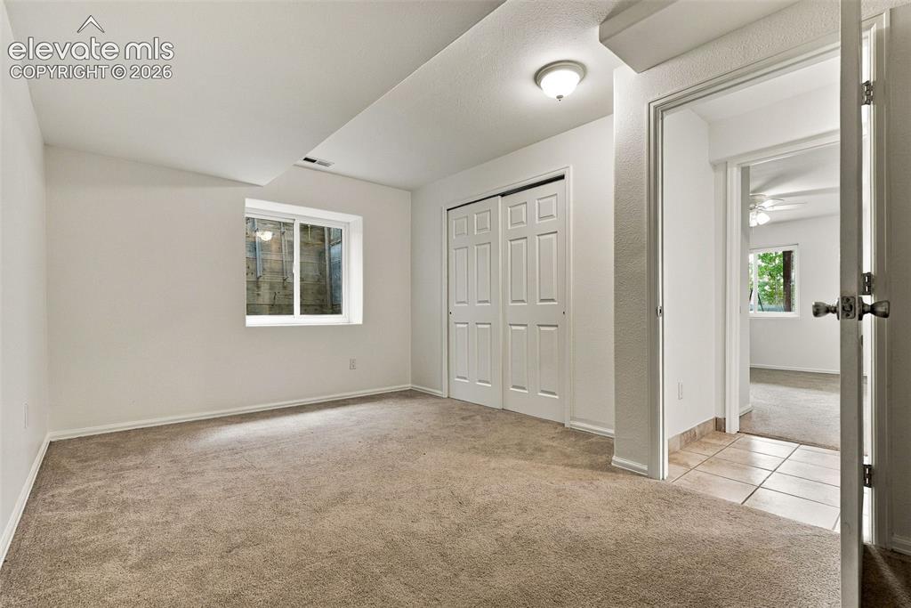 Image 41 of 50: Carpeted room featuring a double-pane window, flush-mount lighting, and whi