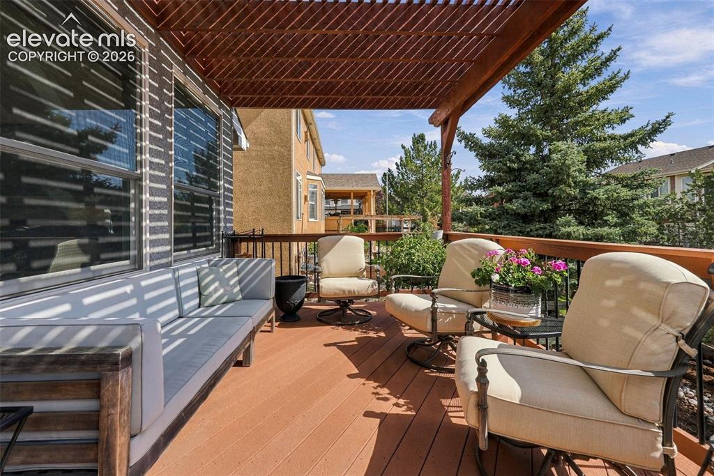Image 43 of 50: Expansive outdoor deck featuring wood-finish flooring, a slatted wood pergo