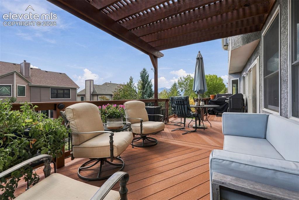 Image 44 of 50: Expansive outdoor deck featuring wood-finish flooring, a full-length pergol