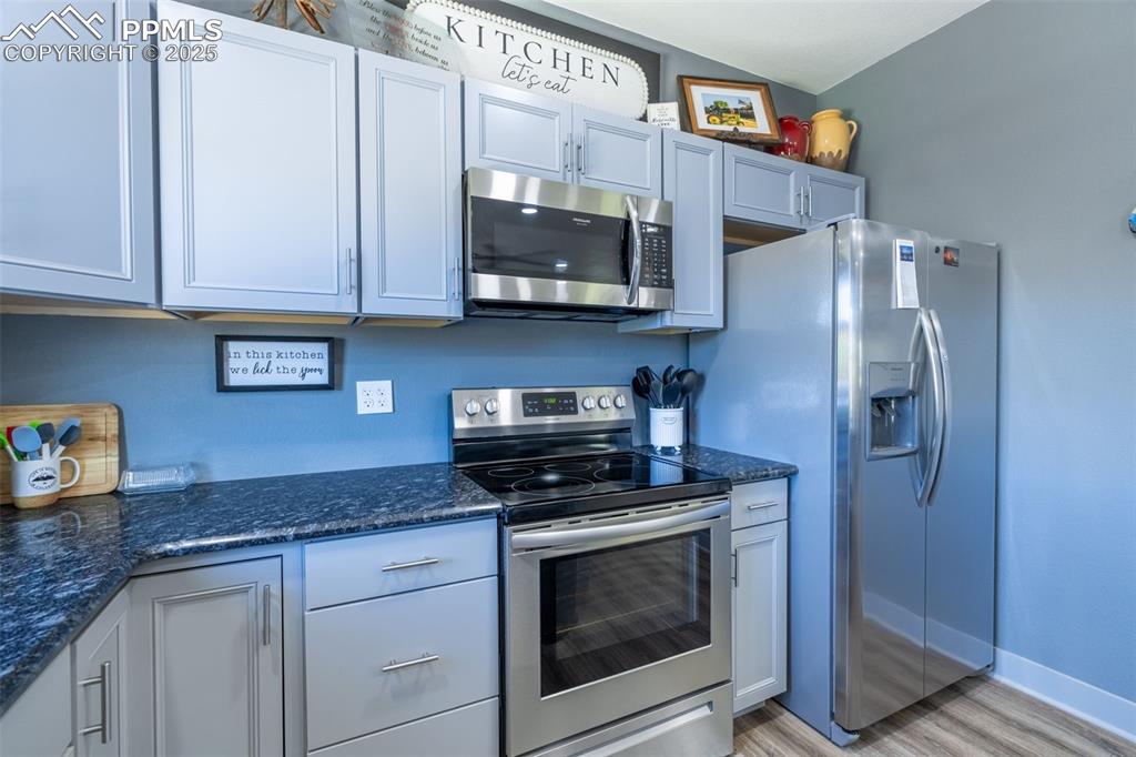 Image 10 of 41: Kitchen featuring appliances with stainless steel finishes, light wood-styl