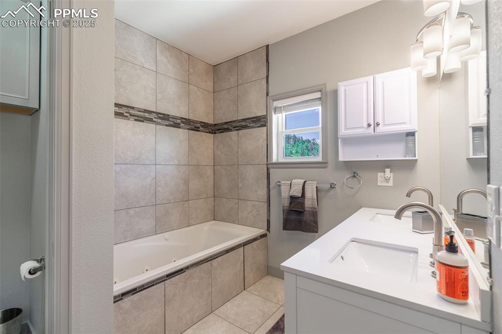 Image 13 of 41: Bathroom with double vanity, tile patterned flooring, and a combined bath /