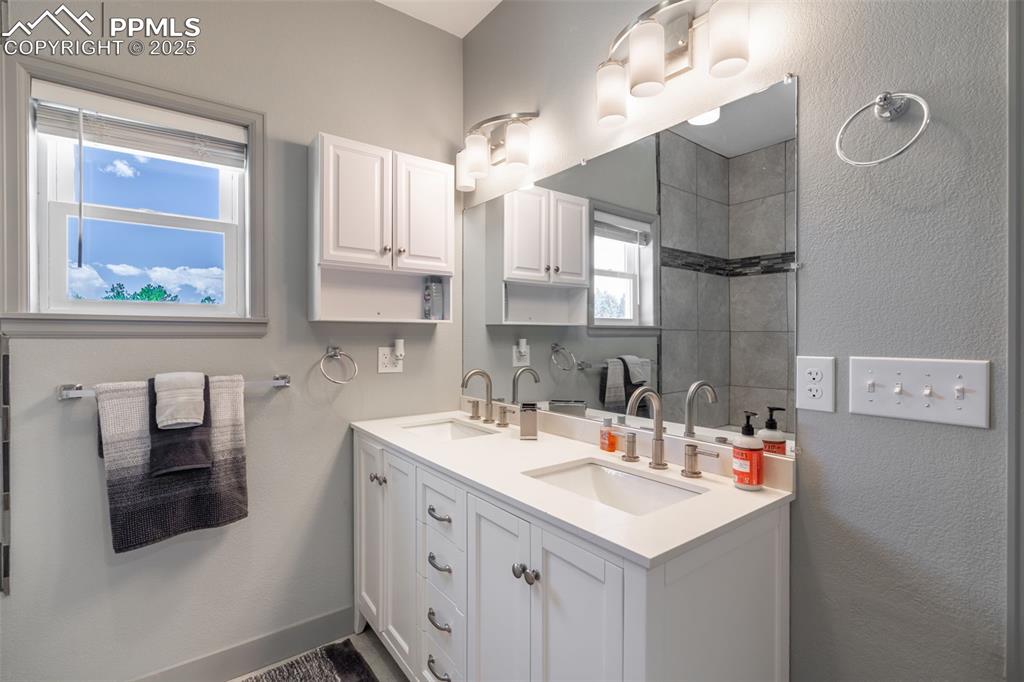 Image 15 of 41: Bathroom with double vanity and healthy amount of natural light