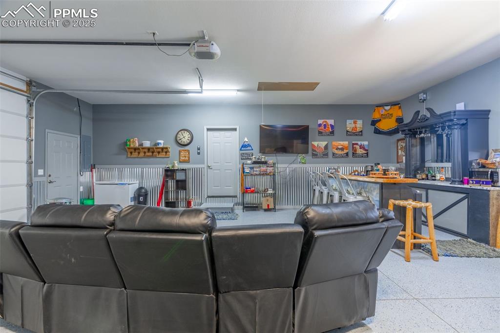 Image 25 of 41: Living room featuring speckle patterned floor and electric panel