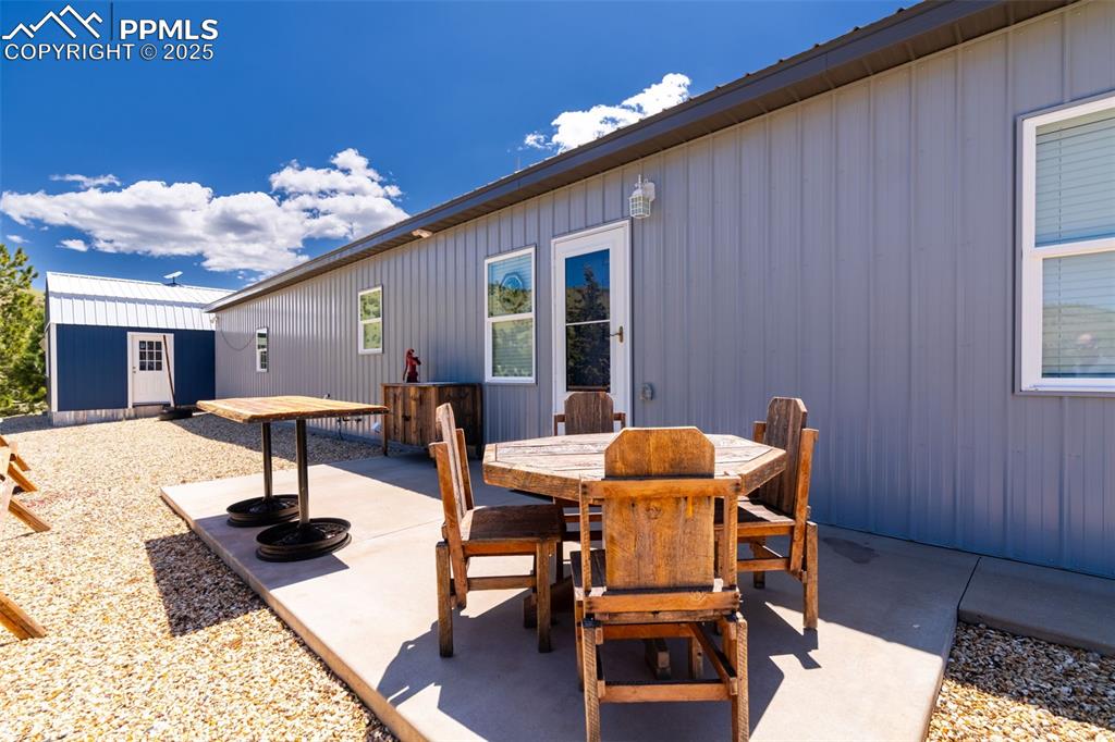 Image 30 of 41: View of patio featuring outdoor dining area and an outbuilding